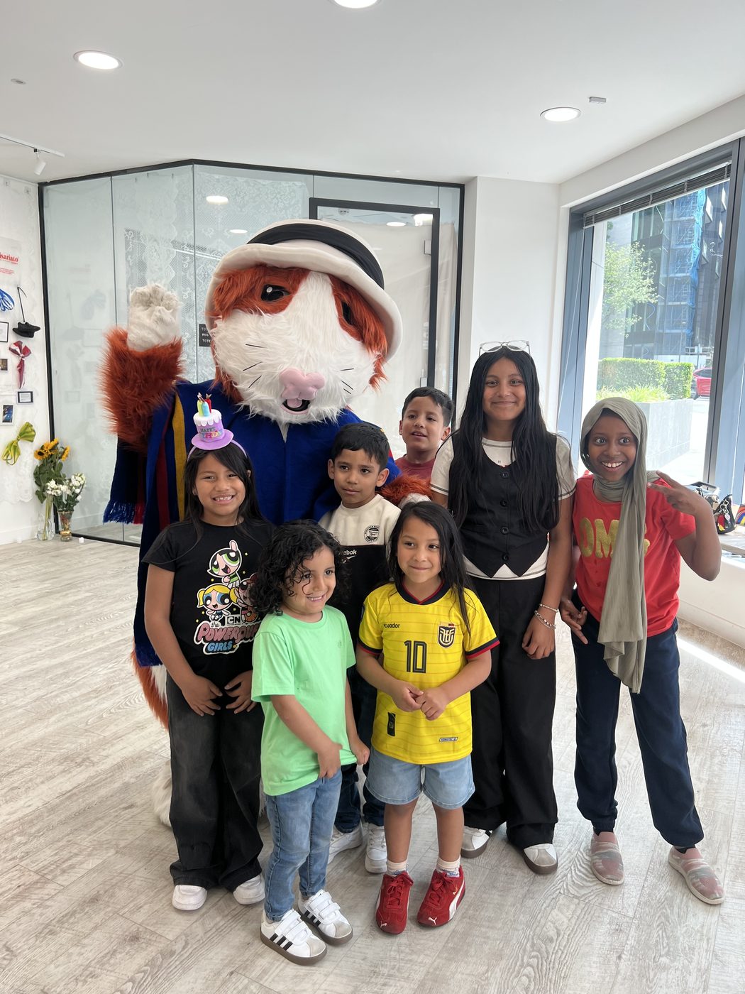 Children posing with an invited mascot, Para Ecuador Con Amor, 2025